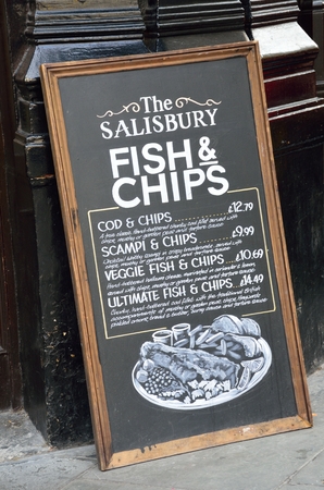 London England, United Kingdom - August 16, 2016: Pub Blackboard sign advertising traditional English Meal of Fish and Chipsのeditorial素材