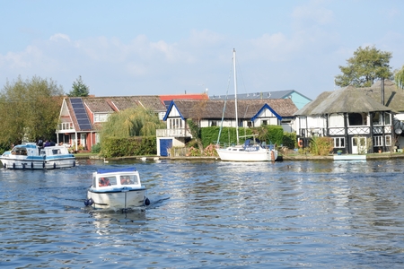 Wroxham Norfolk  , United Kingdom - October 25, 2016: Pleasure boats  on  River Yare centre for tourism on Norfolk Broads with houses  in backgroundのeditorial素材