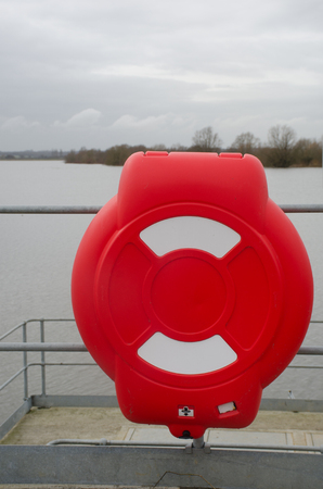 Bright red lifebelt container with reservoir in backgroundの写真素材
