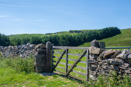 Yorkshire dry stone wall with gate in centerの写真素材