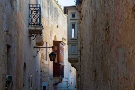 Narrow back street in Mdina Malta with traditional wooden balconiesの写真素材