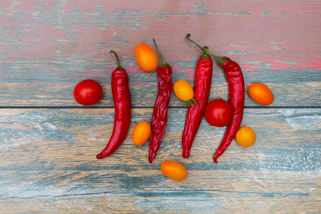 Chili pepper and tomatoes on the wooden tableの写真素材