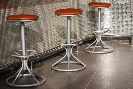 Bar stools in front of colorful mosaic wallの写真素材