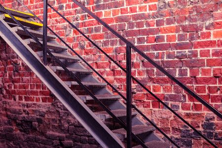 Metal stairway against old brick wall - vivid photoの写真素材