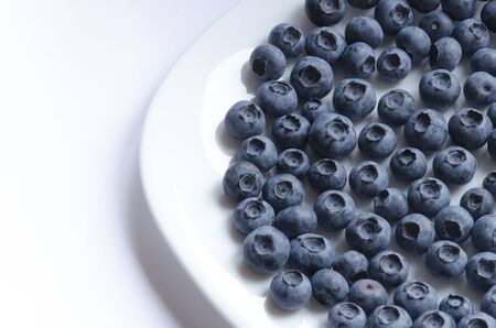 White Plate of big blueberries on white backgroundの写真素材