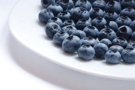 Big blueberries on the plate on white backgroundの写真素材