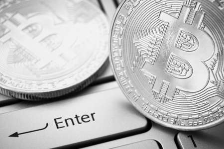 Bitcoins on laptop keyboard near enter button. Black and white photoのeditorial素材