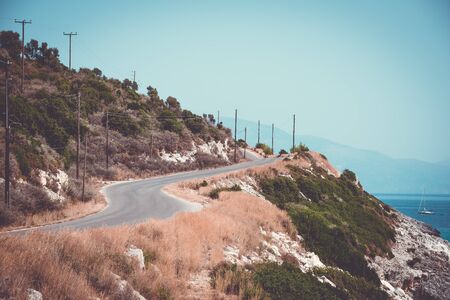 Countryside road winding near the rocky seashore. Vintage styleの写真素材