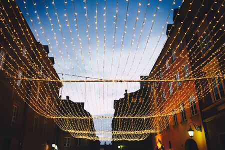 Christmas lights on evening alley in old town