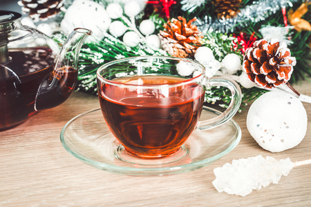 Christmas holiday background with hot cup of black tea, crystal sugar on a stick and Christmas decorationsの写真素材