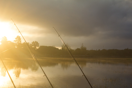 The hook is prepared to fishing since dawn, beneath the sun's orange black cloud. Waterside, Thailandの写真素材