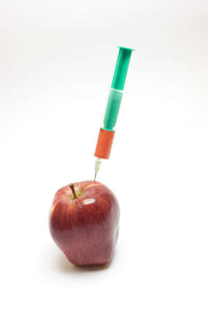 Red apple and syringe over white backgroundの写真素材