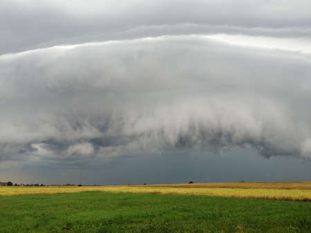 Storm clouds in the sky over the field. Dramatic cloudscape.の写真素材