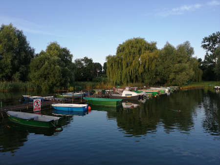 Boats moored in the park on the shore of the lakeの写真素材