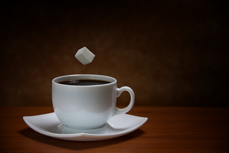 sugar cube being dropped into coffeeの写真素材