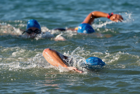 Group people in wetsuit swimming at triathlonの写真素材