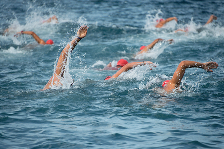 Group people in wetsuit swimming at triathlonの写真素材