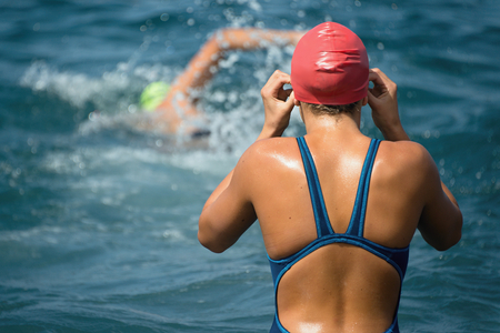 Female swimmer preparing for training in the sea in the background swimmer swims crawlの写真素材