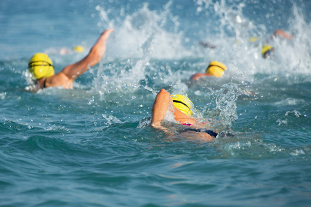 Group of swimmers swim in the blue sea at the racesの写真素材
