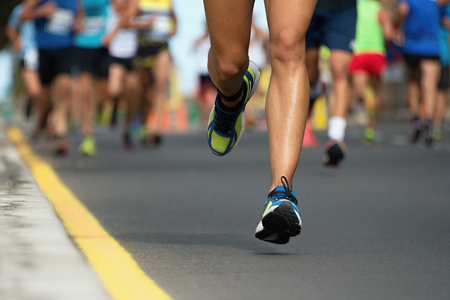 Marathon running race, people feet on city roadの写真素材