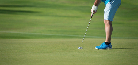 Playing golf preparing to shot,man putting on greenの写真素材