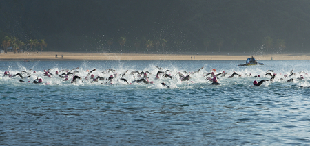 Group people in wetsuit swimming at triathlonの写真素材