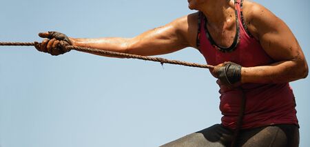 Mud race runners,defeating obstacles by using ropes,tug of warの写真素材