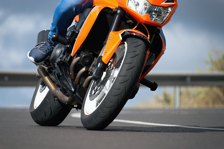 Man riding motorcycle in asphalt road curve with rural,motorcycle practice leaning into a fast...