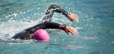 Triathlon long distance swimming, people in wetsuit swimming at triathlonの写真素材