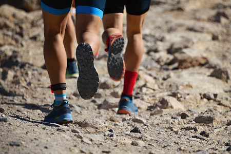 Close-up of the shoes of a group of runners jogging on a mountain pathの写真素材