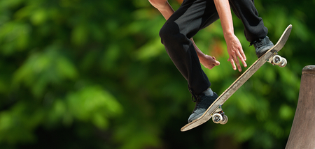 Skateboard flying over a ramp,skateboarder practicing in the skate parkの写真素材
