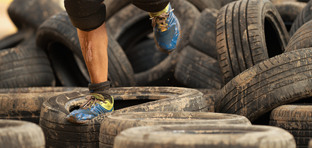Mud race runners, tries to make it through the tire trapの写真素材