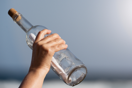 Throwing a message in a bottle hand detailの写真素材