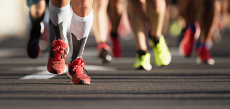 Marathon running race, people feet on city roadの写真素材