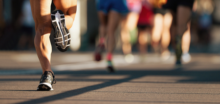 Marathon running race, people feet on city roadの写真素材
