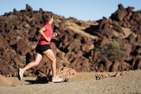 Woman cross country trail runner, running on the mountainの写真素材