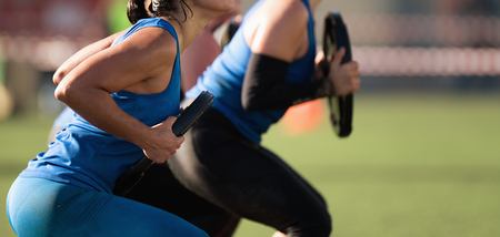 Mud race runners, group of racers squat with a dumbbell