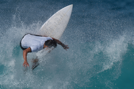 Sports man surfing wave on surfboard in ocean