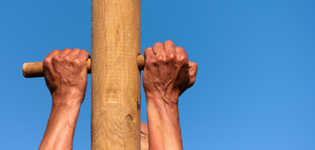 A man climbs onto a pillar, hands detailの写真素材