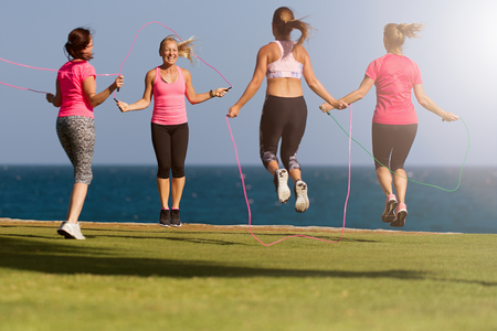 Group of young people doing their fitness training by the sea, using skipping rope