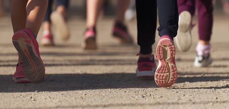 Running children, young athletes run in a kids run race,running on city road detail on legsの写真素材