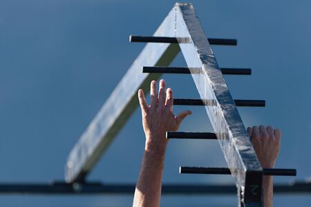 Mud race running over obstacles race runners,hands overcome obstacle.Hand over handの写真素材