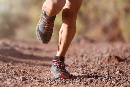 Trail running man on mountain path exercising