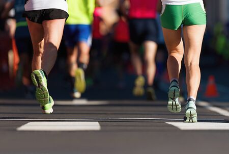Marathon running race, people feet on city roadの写真素材