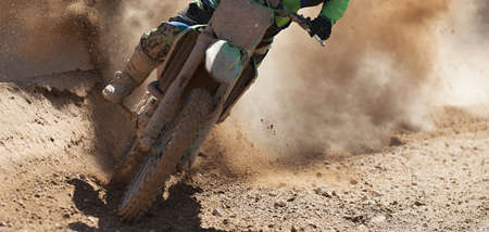 Motocross racer accelerating speed in track, driving in the motocross raceの写真素材