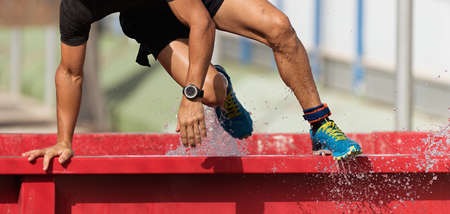 Man overcomes water obstacle on obstacle course. Mud race runnersの素材 [FY310171903228]