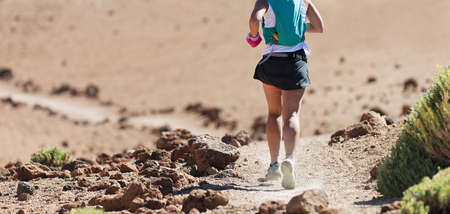 Female athlete run mountain race with hydration trail vest for running