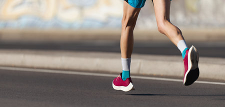 Athlete runner feet running on road close up on shoe, marathon running race