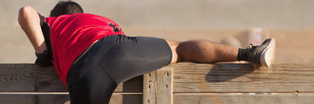 Participant in an obstacle course running and climbing a wall, jump over a wall obstacle