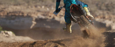 Racer boy on motorcycle participates in motocross race, active extreme sport, flying debris from a motocross in dirt trackの写真素材